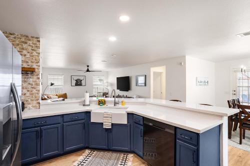 a kitchen with blue cabinets and white counter tops at Relaxing 3BR Austin stay with BBQ & Backyard in Austin