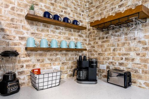 a kitchen with a coffee maker and a brick wall at Relaxing 3BR Austin stay with BBQ & Backyard in Austin