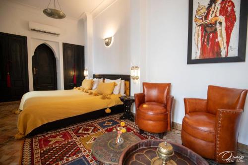 a hotel room with a bed and two chairs at Riad Zoraida in Marrakech