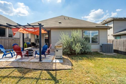 a house with a patio with chairs and an umbrella at Relaxing 3BR Austin stay with BBQ & Backyard in Austin