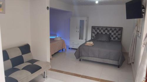 a bedroom with a bed and a chair at Hostal Villa Laurita in Riofrío