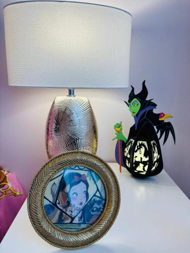 a table with a lamp and a picture in a mirror at THE ENCHANTED HOUSE ( 15 min walk to Disney) in Serris