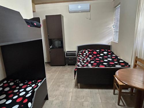 a room with two bunk beds and a table and a tableablish at Family Hotel Nino in Ureki