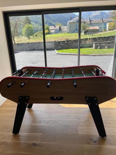una mesa de ping pong frente a una ventana en Gîte L'Après-Ski, Spa, Spacieux, en Campan