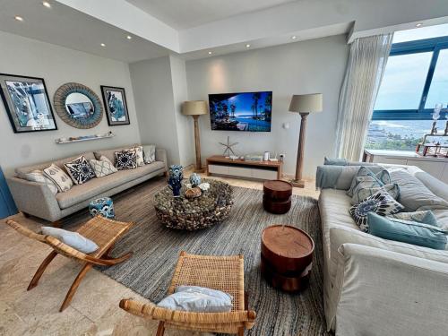 a living room with a couch and a table at Juan dolio Penthouse, beach access 3BR Salitre Tower front of Club Hemingway in Juan Dolio
