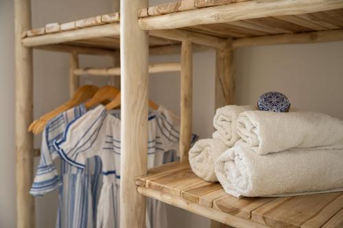 a bunch of towels on a wooden shelf at La SABBIA 3 in Matala