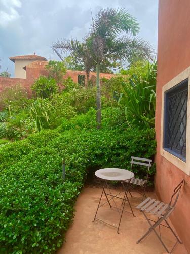 a table and two chairs sitting next to a building at Toubab Dialaw Gareye in Rufisque