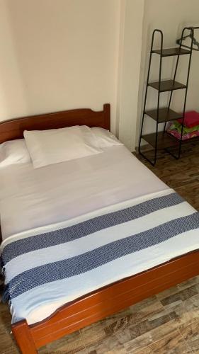 a bed with a wooden frame and a ladder at habitaciones ecopolis en el queremal in El Queremal