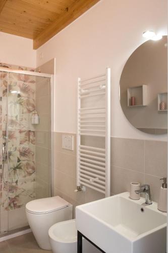a bathroom with a toilet and a sink and a mirror at Dimora Caprera - Appartamenti in Falconara Marittima