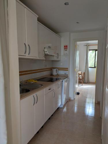 a kitchen with white cabinets and a sink at Oasis Waves House Papagayo in Corralejo