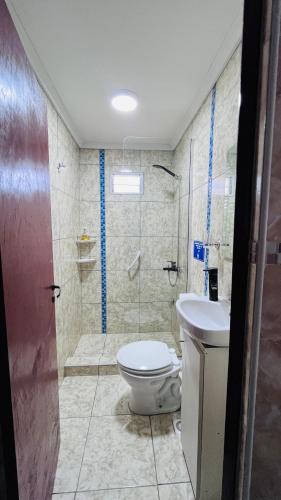 ein Badezimmer mit Toilette, Waschbecken und Dusche in der Unterkunft Casa Huerquen in Neuquén