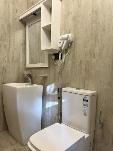 a bathroom with a white toilet and a mirror at King's Palace in Kandy