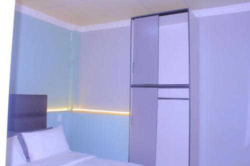 a bedroom with a bed and a glass wall at Drame MC Good Night Lodge in Cape Town