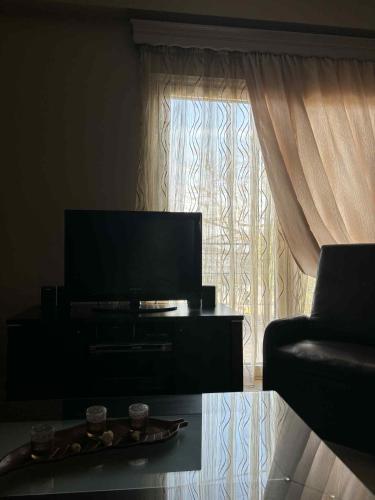 a living room with a television and a couch and a table at Four Seasons House in Ioannina