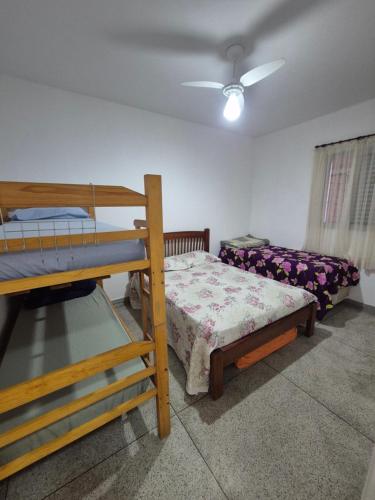 ein Schlafzimmer mit einem Etagenbett und einem Sofa in der Unterkunft Apto 414- Prédio em frente da praia in Praia Grande