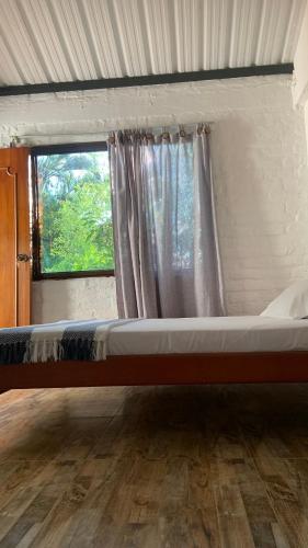 a large bed in a room with a window at habitaciones ecopolis en el queremal in El Queremal