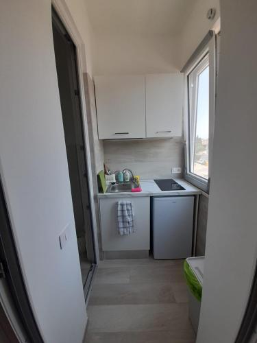 a small kitchen with white cabinets and a sink at Matera Stay in Matera