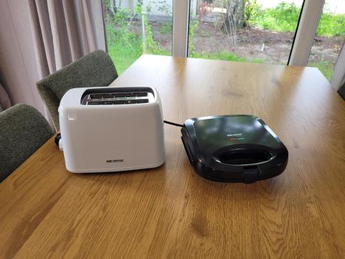 a toaster and a printer sitting on a table at Sola Lodge - Luxe chalet in natuur Overijssel in Mariënberg