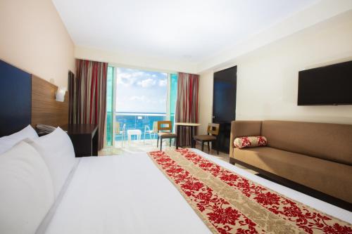 a hotel room with a bed and a couch at Krystal Cancun in Cancún