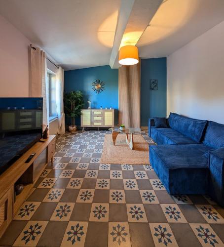 un salon avec un canapé bleu et une télévision dans l'établissement T2 tout confort, cité, parking, à Carcassonne