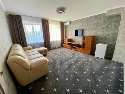 a living room with a couch and a television at Hotel Prydesnyansky in Chernihiv