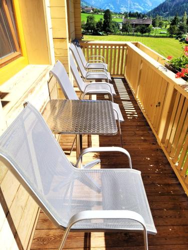 a row of chairs and tables on a porch at Apartment Santnerhof in Virgen