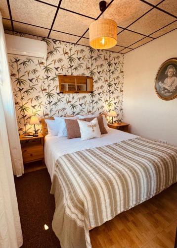 a bedroom with a large bed with a striped blanket at Agrotur Fenix in Telde