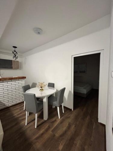 a white dining room with a white table and chairs at Apartman FIKA in Prijepolje