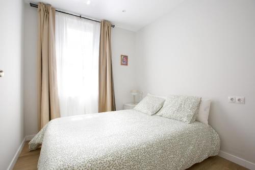 a bedroom with a white bed and a window at Alberto Rooms habitaciones en piso compartido baño y zonas comunes compartido in Bilbao