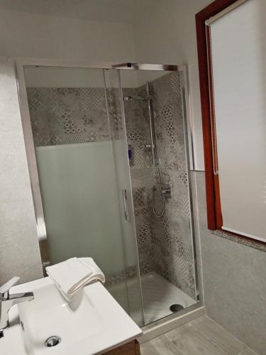 a bathroom with a shower with a sink and a sink at L'Aurora Porto Torres in Porto Torres