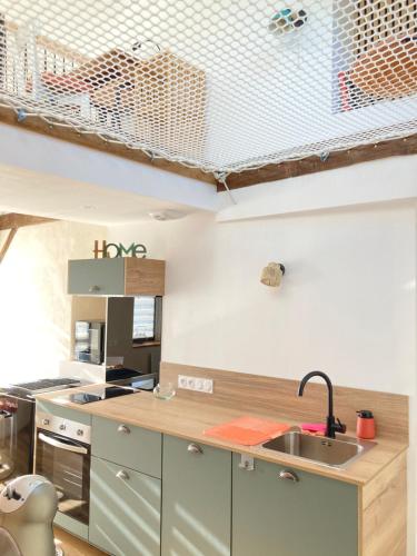 a kitchen with a sink and a counter top at Le petit Grenier de la Fontaine in Vignoc
