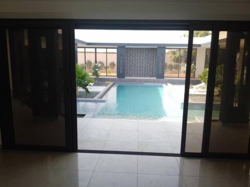 a view of a swimming pool through a sliding glass door at Luxurious 4 bedroom Villa next to the lagoon in Somone