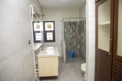 a bathroom with a sink and a shower and a toilet at The Red Tree II Executive Guest House in Karachi