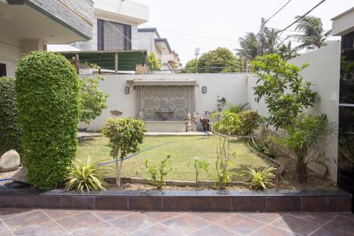 a garden in a house with trees and bushes at The Red Tree II Executive Guest House in Karachi