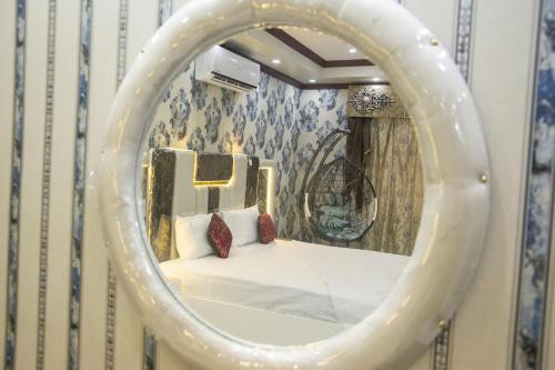 a bedroom with a bed in a mirror at The Red Tree II Executive Guest House in Karachi