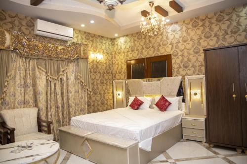 a bedroom with a bed and a chandelier at The Red Tree II Executive Guest House in Karachi