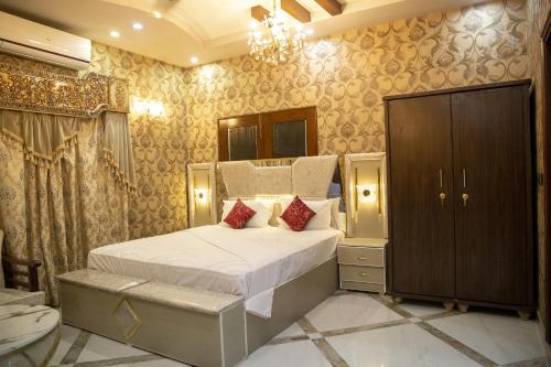 a bedroom with a large bed and a chandelier at The Red Tree II Executive Guest House in Karachi