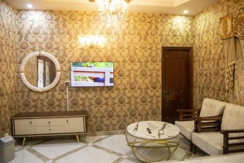 a living room with a couch and a mirror at The Red Tree II Executive Guest House in Karachi