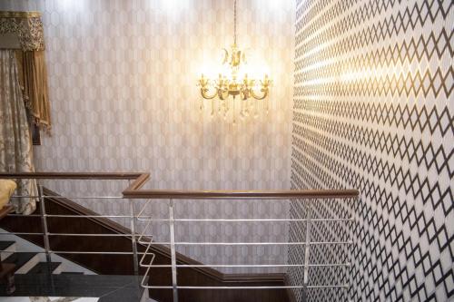 a chandelier is hanging in a bathroom with stairs at The Red Tree II Executive Guest House in Karachi