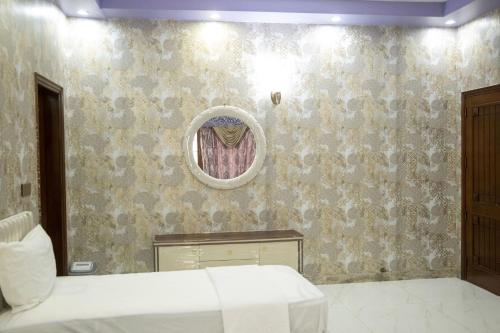 a bedroom with a bed and a mirror on a wall at The Red Tree II Executive Guest House in Karachi
