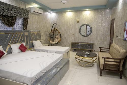 a hotel room with two beds and a fireplace at The Red Tree II Executive Guest House in Karachi