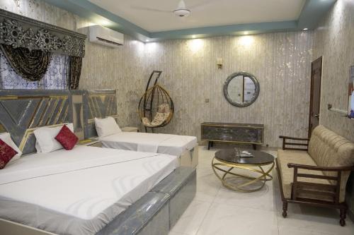 a hotel room with two beds and a table at The Red Tree II Executive Guest House in Karachi
