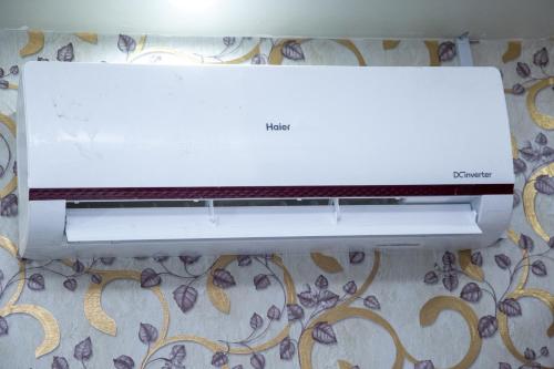 a white microwave oven sitting on top of a wall at The Red Tree II Executive Guest House in Karachi