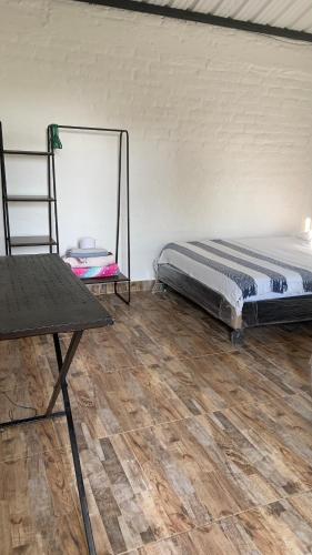 a bedroom with a bed and a wooden floor at Ecopolis Hospedaje en el queremal in Papagalleros