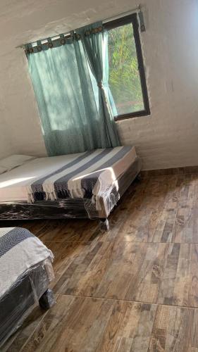 a bed in a small room with a window at Ecopolis Hospedaje en el queremal in Papagalleros