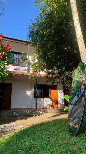 a sign in the grass in front of a building at Ecopolis Hospedaje en el queremal in Papagalleros