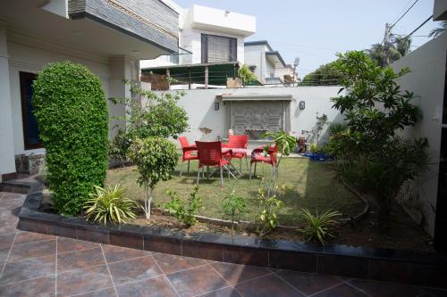 a patio with a table and chairs in a yard at The Red Tree II Executive Guest House in Karachi