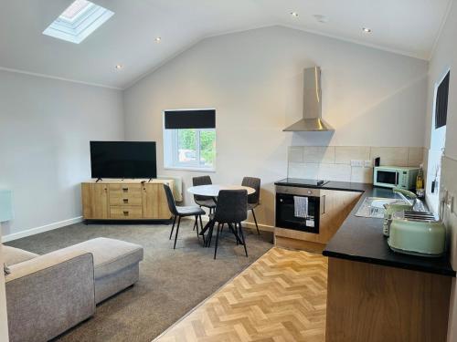a kitchen and living room with a table and chairs at 1 bed ground floor flat free parking in Peterborough