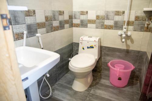 a bathroom with a toilet and a sink at The Red Tree II Executive Guest House in Karachi