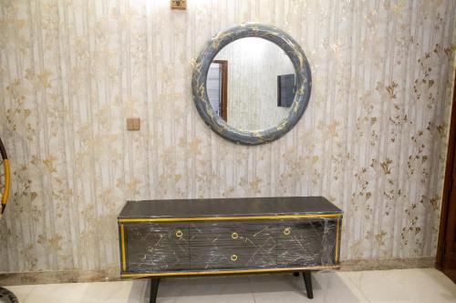 a dressing table with a mirror on a wall at The Red Tree II Executive Guest House in Karachi